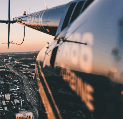 scenic shot from the outside of a helicopter flying over downtown Dallas